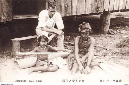 Mariannes - SAIPAN - Une famille assise devant un bungalow